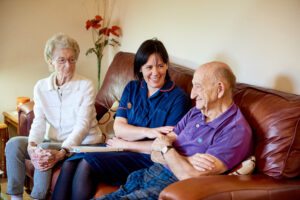 Community nurse with two patients on sofa