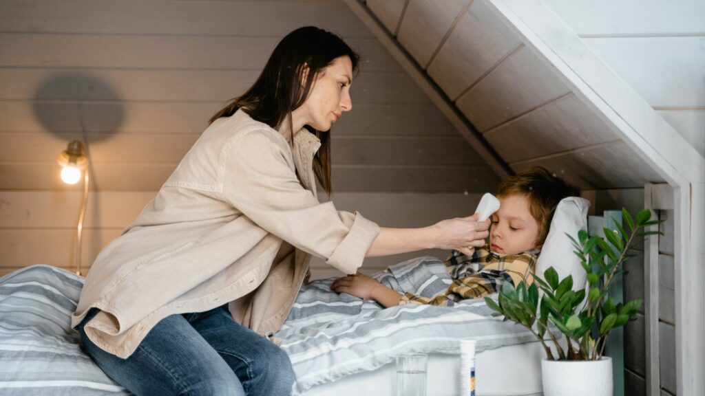 Mother taking temperature of young child