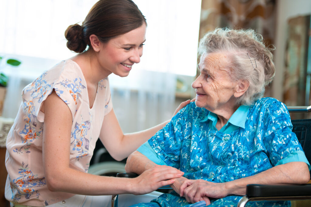 Senior woman in a wheelchair with her caregiver at home
