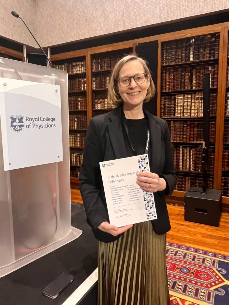 Kathie McPeake, Macmillan Living with Cancer Programme Manager holding Royal College of Physicians (RCP) Eric Watts Award certificate