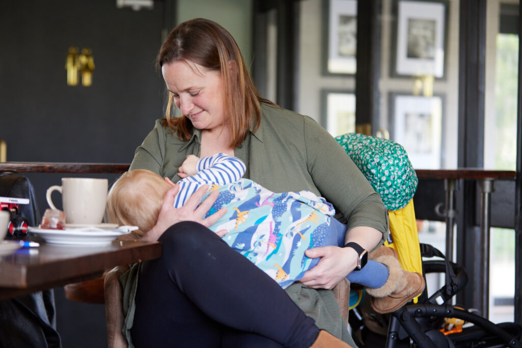 A mother sat breastfeeding her baby in a cafe. Breastfeeding campaign. Credit - Phil Crow Photography