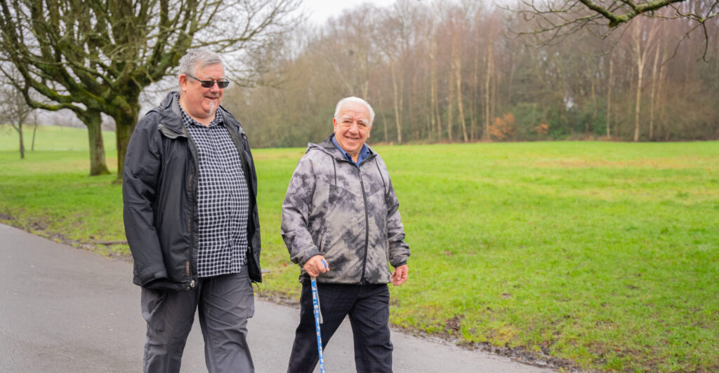 Two older men walking outside