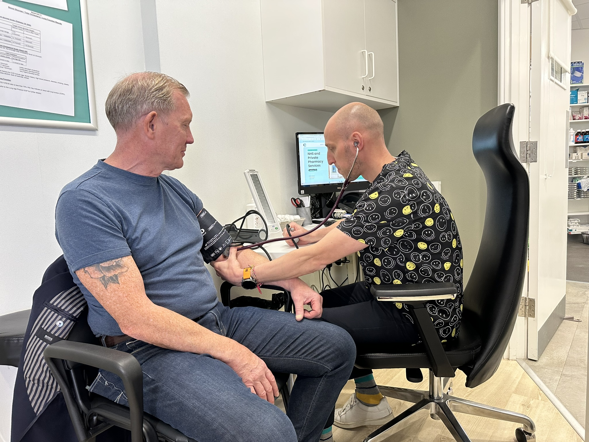 Pharmacist Blazej Jasnowski checking a patient’s blood pressure using a digital monitor at East Midlands Pharmacy.
