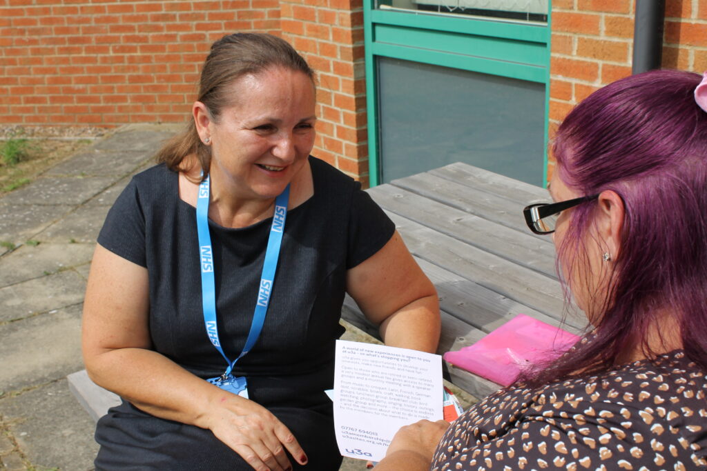 A photo of two women speaking. Elena, a social prescriber and Amanda, a patient.