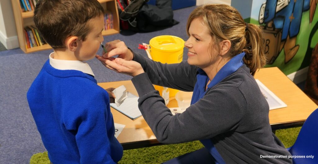 Vaccination nurse giving school child the Flu vaccine