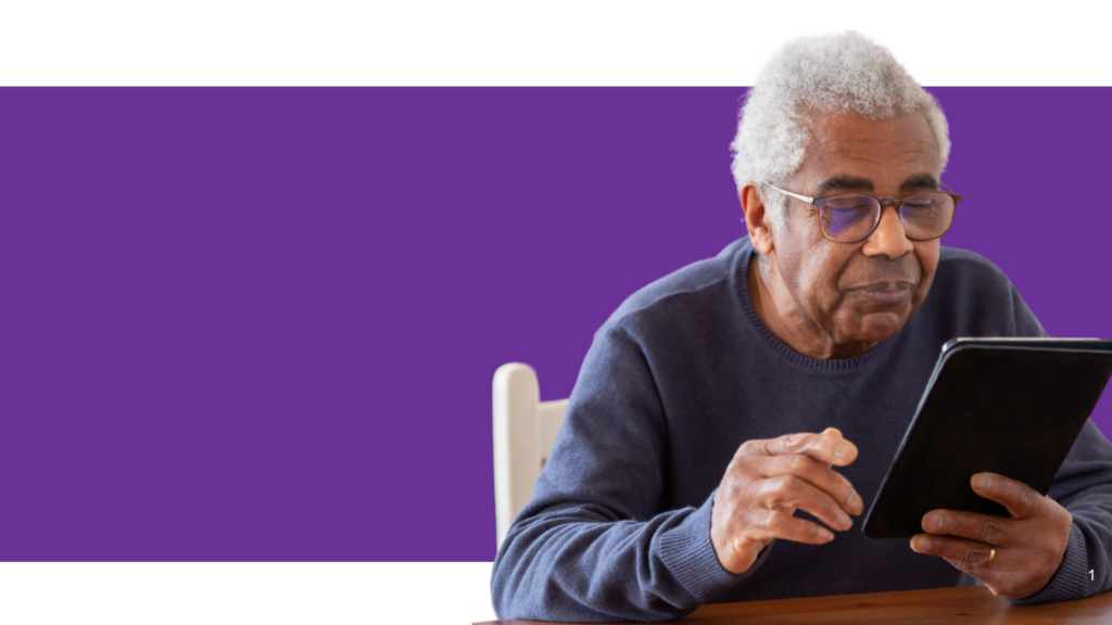 Elderly person using a tablet device while seated against a purple background.