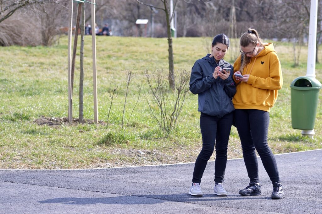 Two young people looking on their mobile phones.jpg