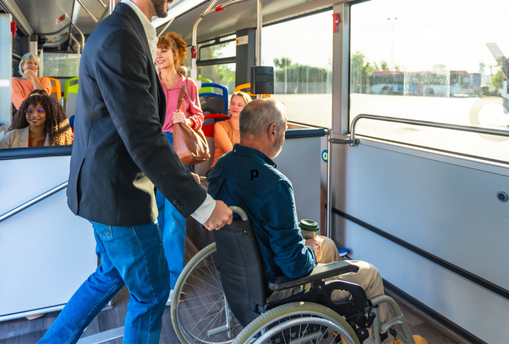 a young male helping a person on a wheelchair on a bus