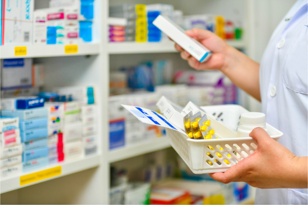 Photograph of a pharmacist filling a prescription, holding medication in a basket