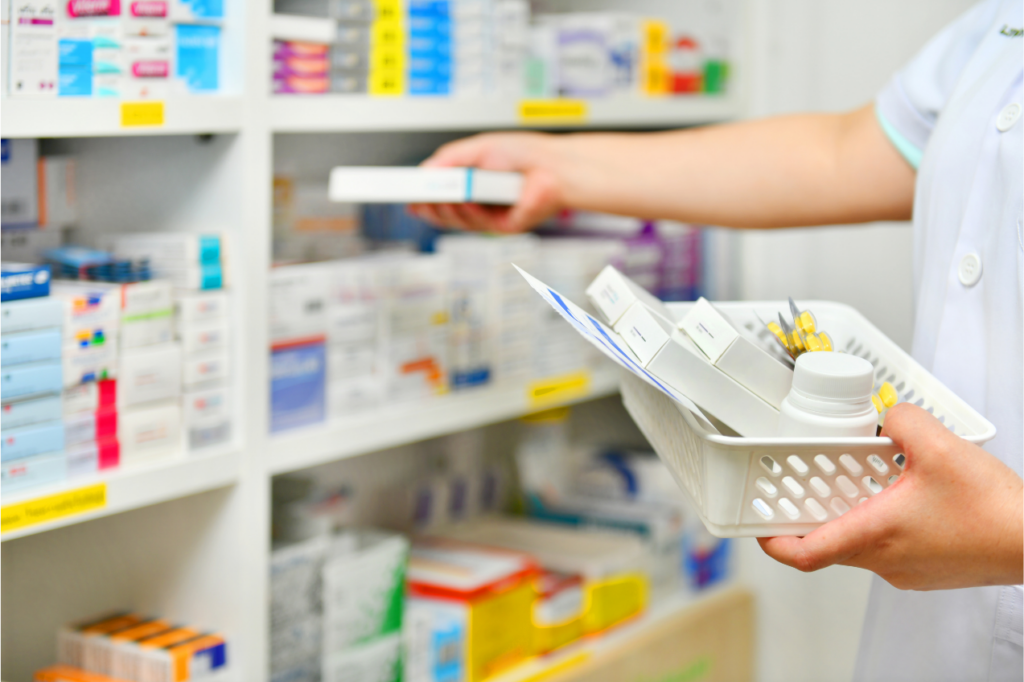 Photograph of a pharmacist filling a prescription basket with different medications