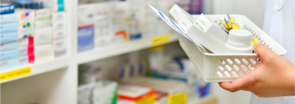 Photograph of a pharmacist filling a prescription basket with different medications