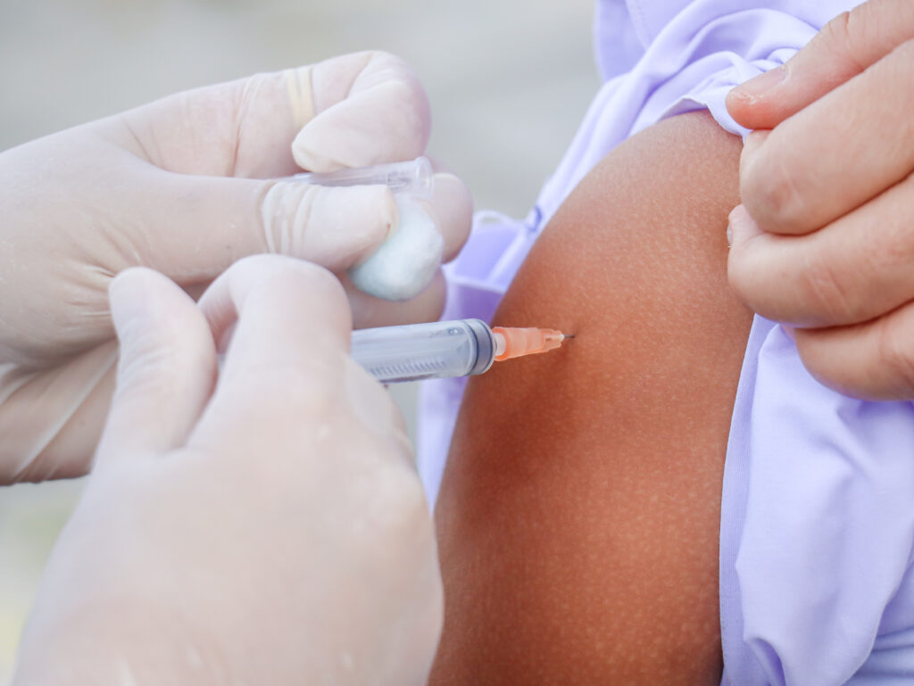 Photograph of a vaccine being administered into an upper arm