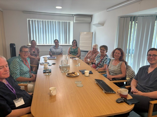 Photograph of people sat round a table R-L Dr Gavin Cattigan – GP Partner Jessica Bawden – Chief Executive, Lakeside Healthcare Ishobel MacNab – PPG representative Judith Hibble – PPG representative Mel Scott - Digital Transformation Manager Jess Szulc – Management Support Teri White – Hub Manager Kathy McLean – Chair of the DLN cluster ICB John Morphy-Godber – Chair of the PPG