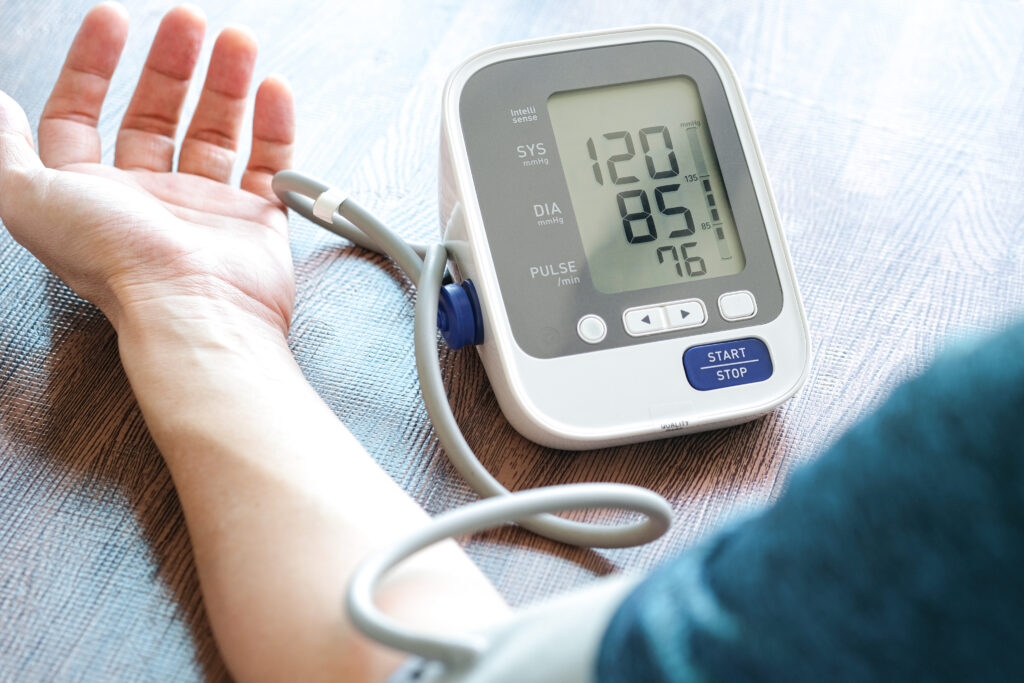 Photograph of a person using a blood pressure monitor attached to their little finger
