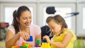 SEND - Woman playing building blocks with young child